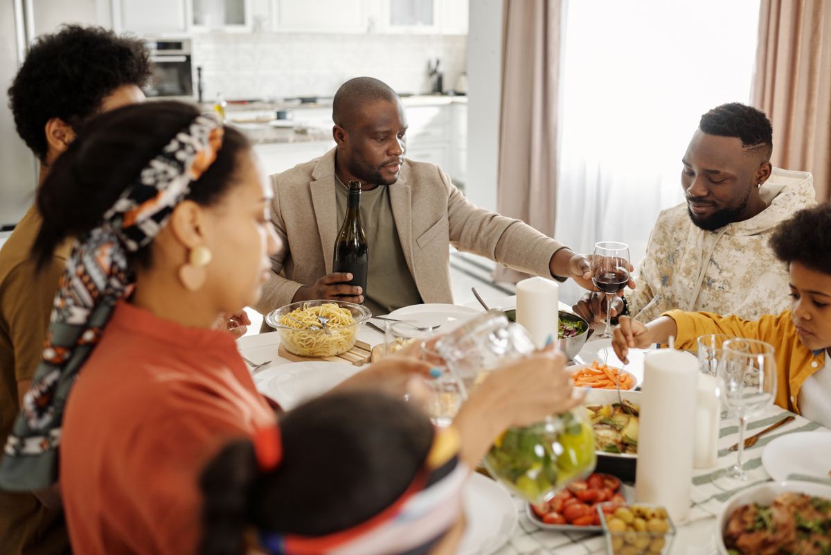 Familia compartiendo la comida alrededor de la mesa; imagen referencial