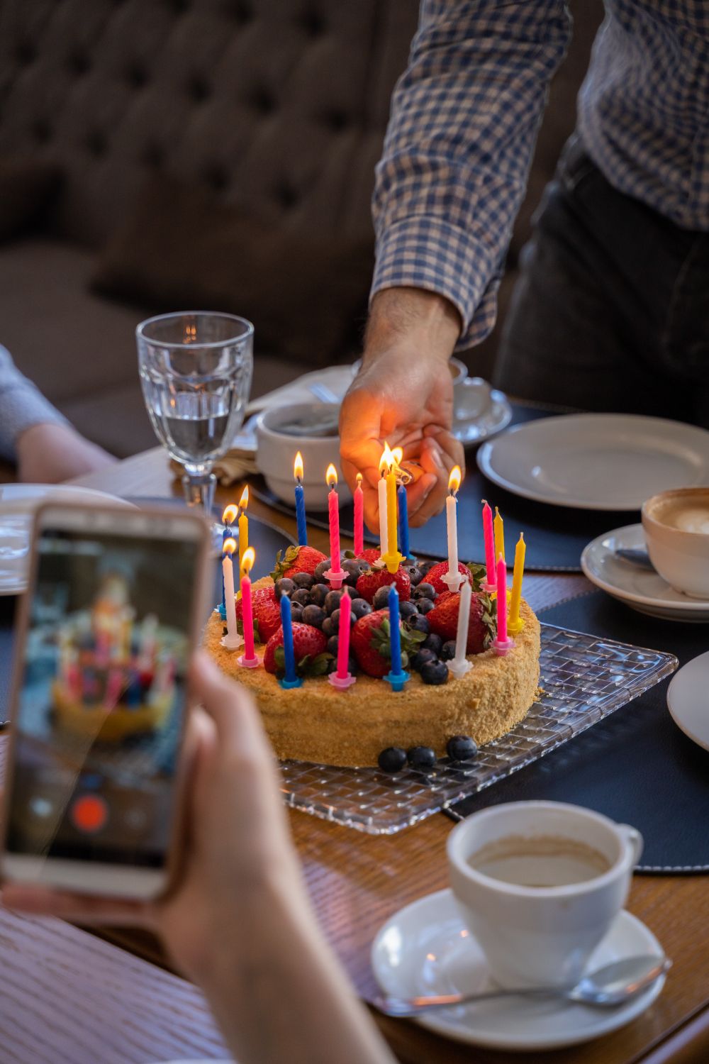 Torta con frutas y velas encendidas en una celebración de cumpleaños; imagen referencial